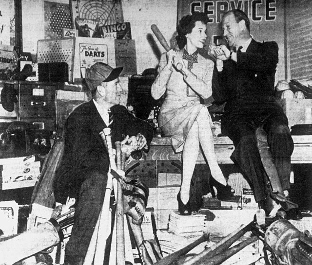 (L-R): Hollywood Stars manger Charlie Root, Jane Wyatt and Los Angeles Angels manager Bill Sweeney sit atop a pile of baseball equipment donated to me