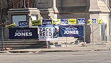 Signs for the campaigns of Zack Reed, Basheer Jones, and Dennis Kucinich in Downtown Cleveland ClevelandMayoralCampaignSigns2021.jpg