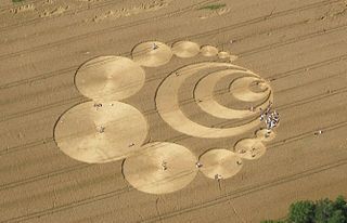 A crop circle, crop formation, or corn circle is a pattern created by flattening a crop, usually a cereal. The term was first coined in the early 1980s by Colin Andrews. Crop circles have been described as all falling 