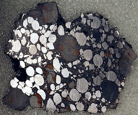 Gujba meteorite, a  bencubbinite found in Nigeria. Polished slice, 4.6 x 3.8 cm. Note the nickel-iron chondrules, which have been age-dated to 4.5627 billion years.