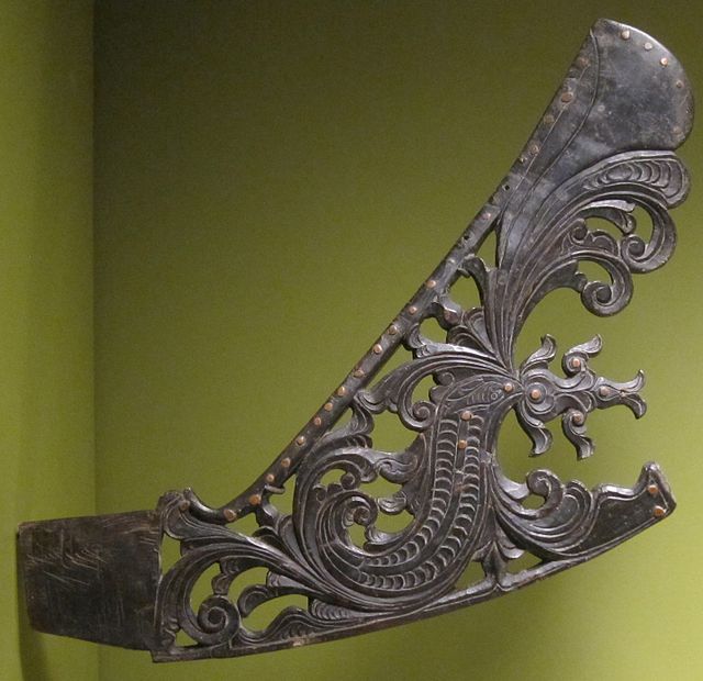A Maranao kubing jaw harp handle made from horn and brass with an S-shaped naga design and a fish