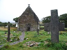 Kilmakedar-Stein (600 n. Chr.) mit Steinkreuz bei Kirchenruine Kilmalkedar, Dingle-Halbinsel, Grafschaft Kerry