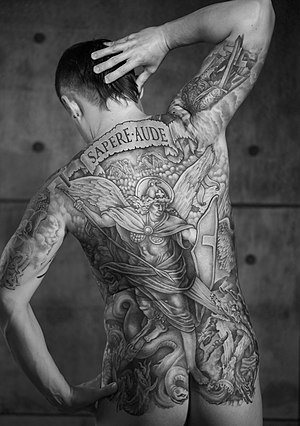Man with a full back tattoo. Michael and the Dragon. Adapted from Die Bibel in Bildern (Revelation) engraving. Enlightenment motto "Sapere aude" is tattooed in the upper back.