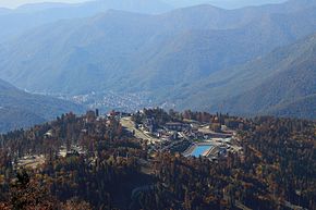 Vista generale di Krasnaya Polyana dalla cresta di Psekhako.  In primo piano c'è il villaggio olimpico di montagna.