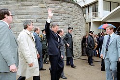 McCarthy (far right) moments before the attempted assassination of Reagan (waving). Left, in white trenchcoat, Jerry Parr, who pushed the President, body-sheltered by McCarthy, into the car. President Ronald Reagan moments before he was shot in an assassination attempt 1981.jpg