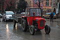 Red tractor and trailer in the rain, Pristina.JPG