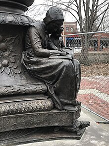 Robbins Memorial Flagstaff in Arlington, Massachusetts, base figure of woman reading with child Robbins Memorial Flagstaff in Arlington Massachusetts by Cyrus Dallin figure of reading woman.jpg