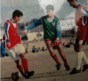 Simo Idrissi is wearing a green jersey and trying to dribble between two players of the same team in a scrimmage game. Simo Idrissi was the youngest player on the adult team. This image represents one of the scrimmage games made every Thursday. Scrimmage games are the method used that allows a coach to pick the final roster for the Sunday games. It's routinely programmed as a pre-game preparation.