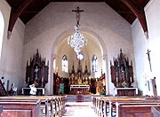 Vue intérieure de la nef vers le chœur et les autels.
