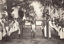 Students training on a gymnastic bar in Malabar in 1905. Students practicing gymnastics in Kerala (1905).jpg