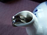 Deutsch: Tropfenfänger aus Metall auf einer Teekanne mit Zwiebelmuster