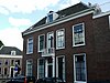 Hoekpand met verdieping en afgeschuinde hoek, een geheel uitmakend met het naastgelegen pand Plompetorengracht 26