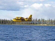 A CL-215 making a low pass above a body of water Waterbomber aircraft (CL-215).jpg