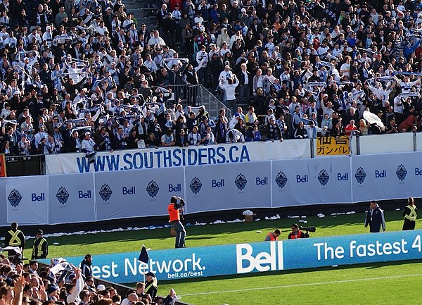 Whitecaps supporters celebrating 4–2 victory over Toronto FC at Empire Field during inaugural MLS match.