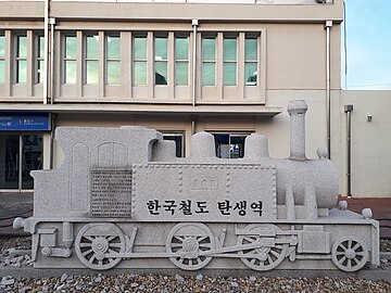 An outdoor plaque of a steam engine commemorating the birth of Korean rail