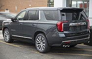 2021 GMC Yukon Denali in Hunter Metallic, rear left.jpg