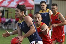 Player lunging to tackle an opponent in possession of the ball Australian rules tackle.jpg