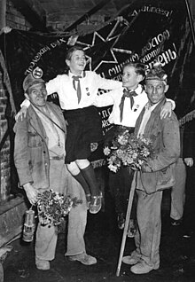 Miners and pioneers pose in front of the Banner of Krivoi Rog. 1952. Bundesarchiv Bild 183-17031-0001, Bergarbeiter, Ehrung.jpg