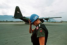Миротворец Организации Объединенных Наций из Норвегии держит свой шлем, когда транспортный самолет Hercules C-130 приземляется в аэропорту Сараево летом 1992 года