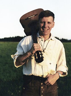 Frank Rennicke con una guitarra en una mañana de verano.