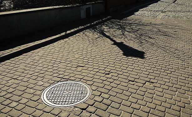 Gray paving stones and a canal manhole cover_Lublin_Poland