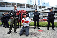 Artist Kacey Wong protesting against the Causeway Bay booksellers disappearances. The sign in his hand says "Hostage is well". 10 February 2016 Kidnap by Kacey Wong.jpg