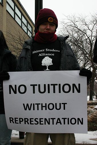 Shimer College student holds "No tuition without representation" sign during protest over school governance in 2010.