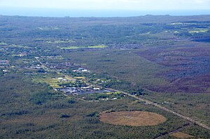 Marzo de 2015. Mirando hacia el sur, hacia la ciudad de Pāhoa , y hacia el sudoeste, hacia el flujo de lava desde Pu'u 'O'o, delineado por la vegetación quemada