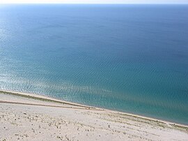 Lake view from the Sleeping Bear Dunes National Lakeshore, with people climbing uphill