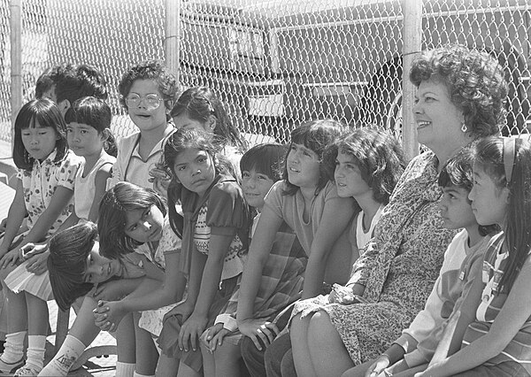 A school principal with a diverse group of students during school integration, 1980.