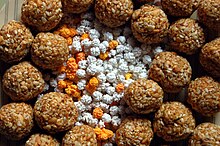 Tilgul is exchanged by Deshasthas on Makar Sankaranti. The centre shows sugarcoated sesame seeds surrounded by laddus of tilgul or sesame jaggery. Tilgul kha god god bola.jpg