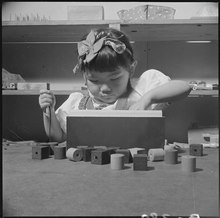 A young internee playing in a nursery school Topaz, Utah. Educational games are part of the prescribed course of study in the nursery schools at . . . - NARA - 537016.tif
