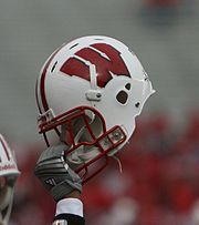 A player holding his helmet by the face mask Wisconsin Helmet.jpg