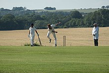 A cricket bowler on Broadhalfpenny Down in mid delivery