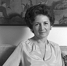 Photographie en noir et blanc d'une femme caucasienne assise, cheveux bruns coiffés en mise en pli, entre 30 et 40 ans