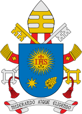 Blaues Wappenschild mit einer gelben Sonne, in dessen Mitte die roten Initialen IHS mit einem roten Kreuz gesetzt sind. Unter der Sonne sind ein gelber Stern und eine gelbe Blüte. Über dem Wappen befindet sich die Papstkrone mit zwei Schlüsseln und unter dem Wappen steht der Spruch „Miserando Atque Eligendo“.