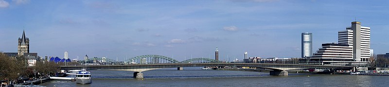 View from the south. The green iron arches belongs to the bridge behind (Hohenzollernbrücke). On the left Groß St. Martin, on the right KölnTriangle and the old Lufthansa headquarter