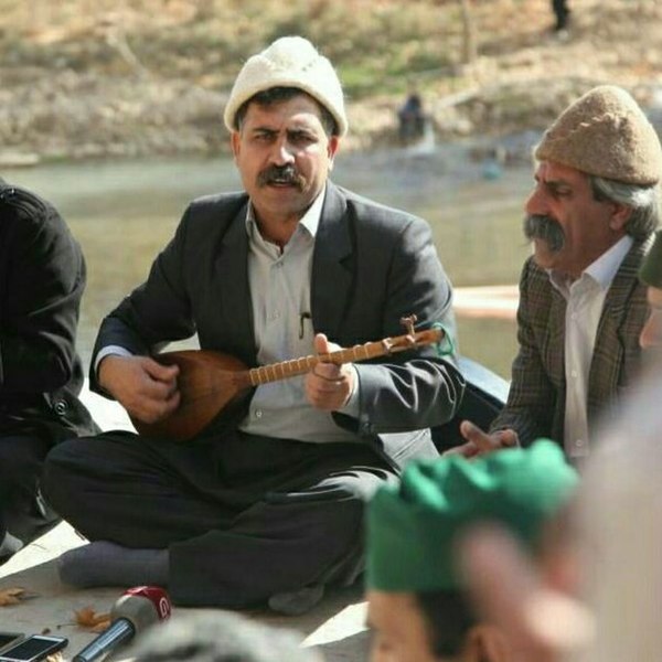 Man playing a tanbur-family instrument