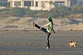 Mädchen kickt einen Ball am Strand von Morro Beach, Kalifornien