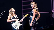 Taylor Swift and Alana Haim performing.