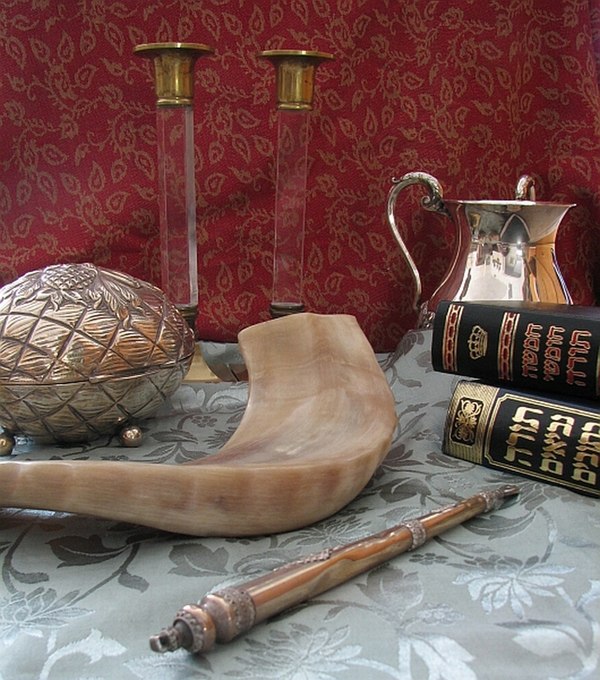 Collection of Judaica (clockwise from top): Candlesticks for Shabbat, a cup for ritual handwashing, a Chumash and a Tanakh, a Torah pointer, a shofar,