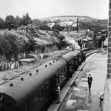 A Brecon train prepares for departure from Neath Riverside on 14 July 1962, a few months before closure. The South Wales main line crosses on the overbridge in the distance RK7.H17 EN.jpg