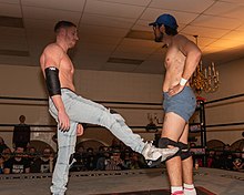 Orange Cassidy hitting one of his signature "Kicks of Doom" on Dan the Dad Orange Cassidy Alpha-1 Dec 2019B.jpg