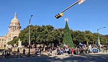 People surround a large Christmas tree outside the Texas state capitol.