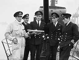 Fotografia de cinco homens de uniforme no convés do HM Submarine Seraph