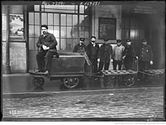 Tracteur électrique tirant des chariots dans une gare (1920)[17].