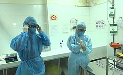 Two Da Nang medical workers wearing protective suits before performing COVID test. Wearing protective suits at Da Nang CDC.jpg