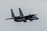 An F-15E Strike Eagle, tail number 91-0320, taking off from RAF Lakenheath in England. The aircraft is assigned to the 494th Fighter Squadron.