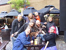 Die A-Band beim Edinburgh Fringe Festival, 2009. Hintere Reihe: Pete Herring, Karl Waugh, Stewart Greenwood. Mitte: Stewart Keith, Seth Cooke, Gardyloo SPeW. Vorderseite: Andrew Fletcher, Greta Pistaceci.