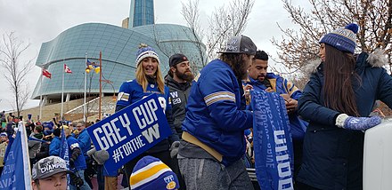 Andrew Harris with his wife (right) and Jeff Hecht at the 2019 Grey Cup parade in Winnipeg